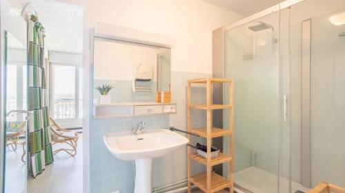 阿卡雄Epsom - Appartement en front de mer Arcachon的一间带水槽和淋浴的浴室