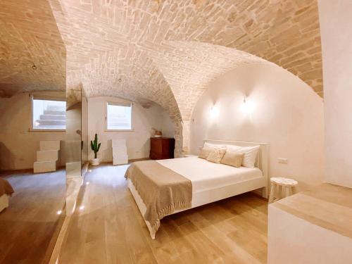莫尔费塔INDE Á LA TERRE, GUEST HOUSE Locazione Turistica的一间石质天花板卧室内的一张床