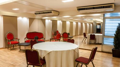 圣米格尔·德·图库玛梅特罗珀尔酒店的一间会议室,配有白色的桌子和椅子