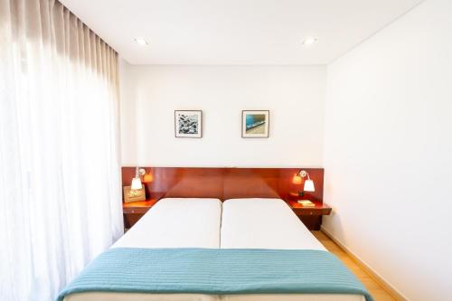 波瓦-迪瓦尔津Apartamento Mar & Sol的一间卧室设有一张床和一个窗口