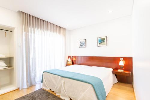 波瓦-迪瓦尔津Apartamento Mar & Sol的一间卧室设有一张床和一个大窗户