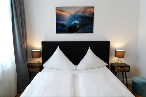 科隆库普菲克瑟尔酒店的卧室配有带两盏灯的白色床