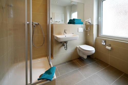 科隆库普菲克瑟尔酒店的带淋浴、盥洗盆和卫生间的浴室