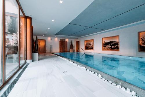 塞尔瓦迪加尔代纳山谷尼维斯精品酒店 - 多洛米蒂豪华设计的一座大型游泳池,位于一座带大型游泳池的建筑内
