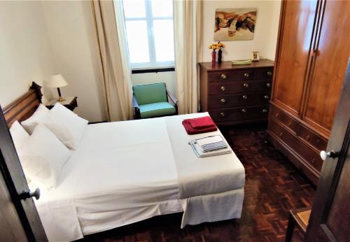 阿尔坎塔里利亚Quinta dos Reis的卧室配有白色的床和椅子