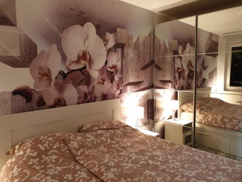 诺维萨德Apartman 33 FREE PRIVATE GARAGE的卧室配有一张床,墙上挂着花壁画