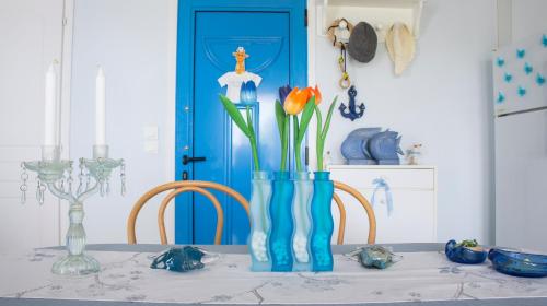 帕利乌里翁Blue Paradise maisonette的一张桌子,上面有花草,上面有蓝色花瓶