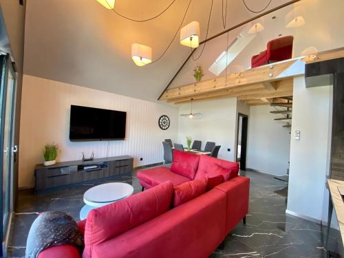 乌斯特龙Apartament LUX Ustroń的客厅配有红色沙发和电视