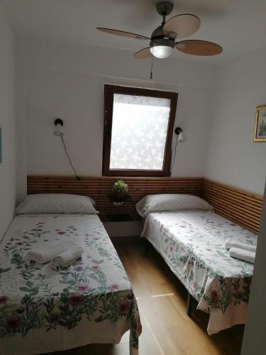 瓦伦西亚Malvarrosa apartamentos的带窗户的客房内的两张床
