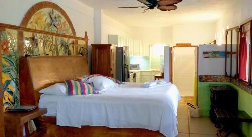 El PlacerMayan Beach Garden的卧室配有白色的床和冰箱。