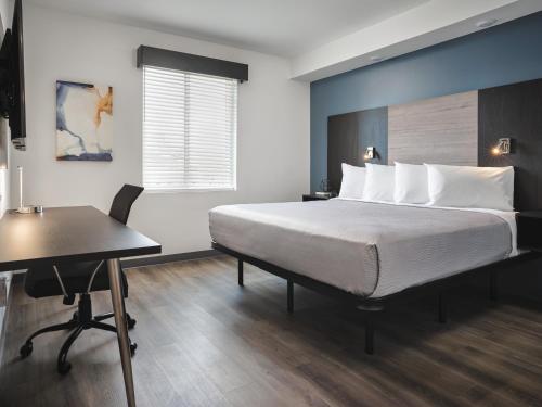 戈尔兹伯勒stayAPT Suites Goldsboro-Seymour Johnson AFB的一间卧室配有一张床、一张桌子和一张桌子