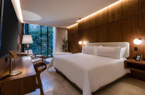 麦德林Elcielo Hotel & Restaurant的卧室配有一张白色大床和一张书桌