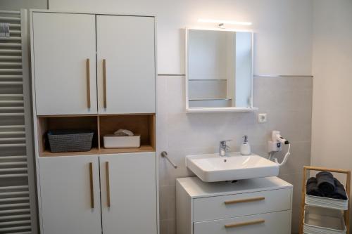 奎德林堡4 Sterne Ferienwohnung , 65 qm的白色的浴室设有水槽和镜子