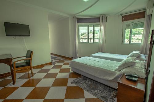 丹吉尔Motel Gzenaya的一间卧室配有一张床、一张书桌和一台电视
