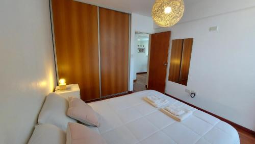 罗萨里奥Cálido y hermoso Dpto. en excelente zona de Rosario的卧室配有一张白色大床和镜子