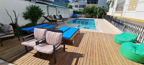 凯麦尔卡拉家庭公寓式酒店的一个带桌椅的甲板和一个游泳池