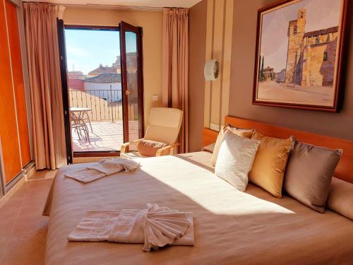 夫罗米斯塔HOTEL RURAL San Pedro的酒店客房设有一张大床和一个阳台。