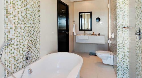 乌平通The Oasis的带浴缸、卫生间和盥洗盆的浴室