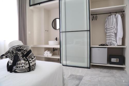 埃尔莫波利斯OIKO MINI SUITES的一间设有一张床和一个玻璃衣柜的房间