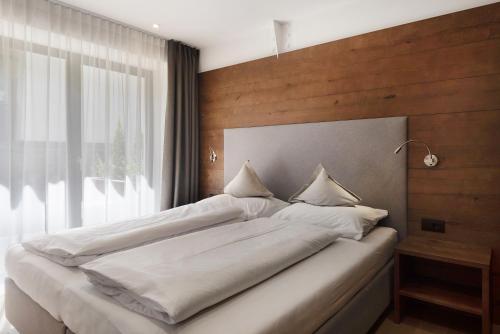 奥蒂塞伊Apartments Montblanc Sella的卧室设有一张白色大床和一扇窗户。