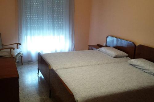CampomanesAPARTAMENTOS CAMPOMANES的卧室在窗户前配有两张床