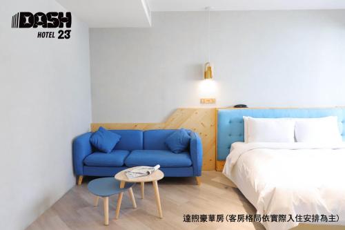台南达煦23旅店的一间卧室配有蓝色的沙发和一张床