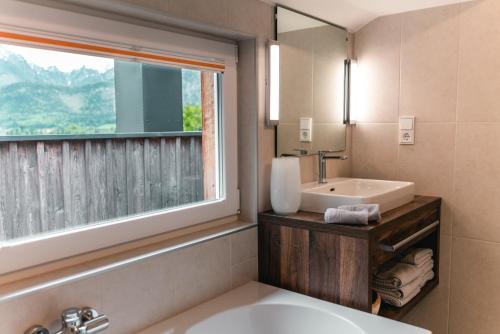 圣沃尔夫冈CHICLIVING Appartements的带浴缸、水槽和窗户的浴室