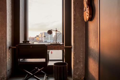 阿姆斯特丹Sir Adam Hotel, part of Sircle Collection的享有城市美景的窗户前的椅子