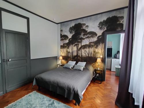 RaismesLa Victorine的一间卧室配有一张壁画床
