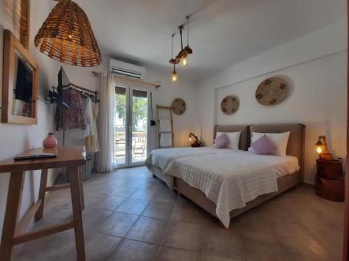 Glinado NaxosJanakos View Apartment with Private Pool的一间卧室配有一张床、一张桌子和一个窗户。
