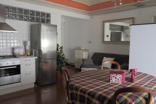塞勒里古B&B La Torre Celle Ligure的厨房配有桌子和不锈钢冰箱。