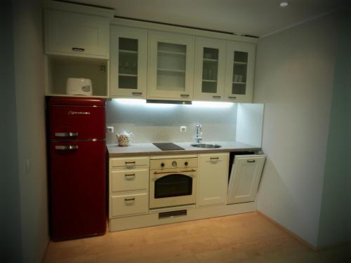 派尔努瑟万科特阿伊达公寓的厨房配有白色橱柜和红色冰箱