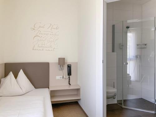 林茨洛可莫蒂夫酒店的一间卧室设有一张床、淋浴和卫生间