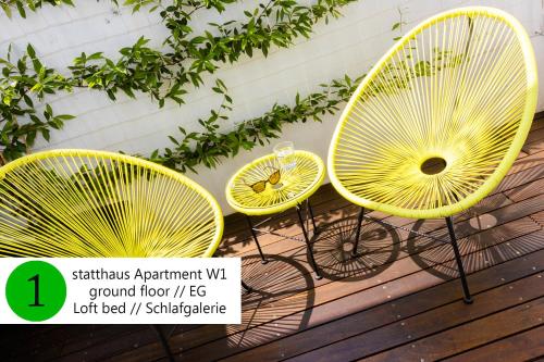 科隆statthaus - statt hotel的木甲板上摆放着三把黄色椅子