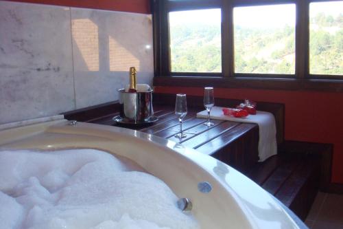 坎波斯杜若尔当瑞坎多松霍斯旅馆的带浴缸的客房设有桌子和窗户。
