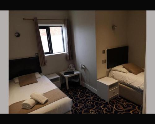 DesboroughThe R Inn Hotel的酒店客房设有两张床和窗户。