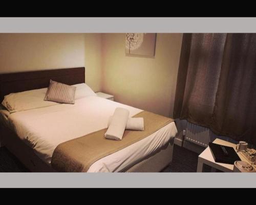 DesboroughThe R Inn Hotel的一间酒店客房,配有一张带毛巾的床