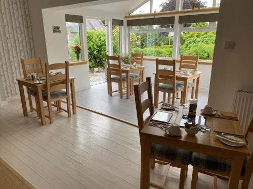 牛顿斯图尔特Stables Guest House的用餐室设有桌椅和窗户。