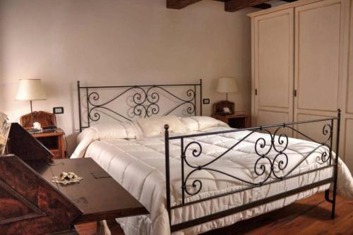 阿巴迪亚圣萨尔瓦托雷Santa Maria ad Valetudinarium的一间卧室配有一张带白色床单和一张桌子的床。