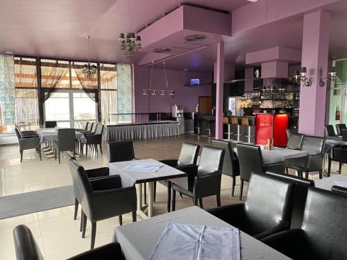 斯维诺乌伊希切Graal SPA的餐厅拥有紫色的墙壁和桌椅