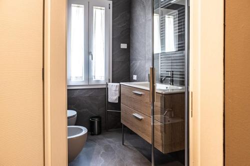 特雷维索Trevisi27的一间带水槽、卫生间和镜子的浴室