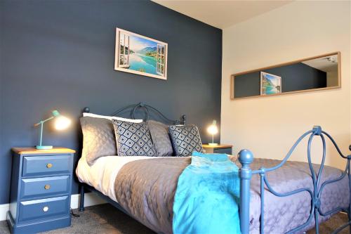 金斯林BrickSage Rooms, King's Lynn South Gate的一间卧室配有蓝色的床和蓝色梳妆台