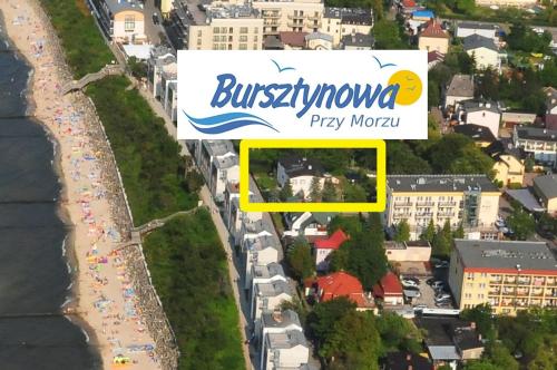 尤斯托尼莫斯基Bursztynowa Przy Morzu - 1 minuta do plaży的海滩上方的景观,带有标志