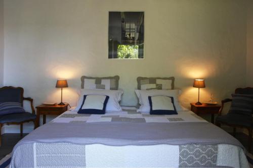 Blaison拉布特高赫尔住宿加早餐旅馆的一间卧室配有一张带两把椅子和两盏灯的床。