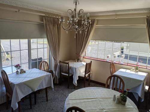 Achill Sound穆拉维尔住宿加早餐旅馆的一间带2张桌子和吊灯的用餐室