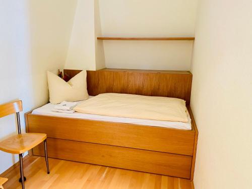 黑灵斯多夫Villa Schlossbauer - Ferienwohnung 13的一张位于小房间的床,配有木制床头板