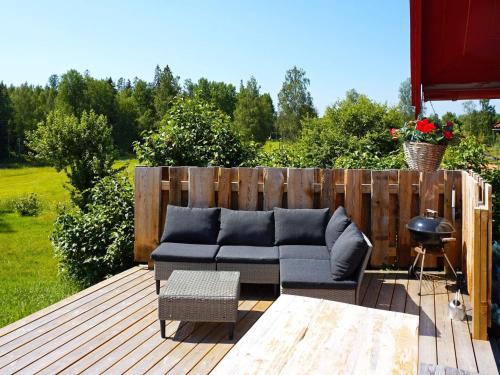 Mellösa5 person holiday home in Mell sa的平台上设有带沙发和桌子的庭院