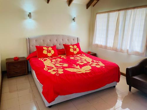 阿鲁坦加Tavake Villa的一间卧室配有红色的床和红色枕头