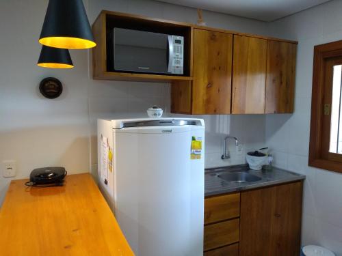 卡内拉Residencial Franzen的厨房配有白色冰箱和水槽
