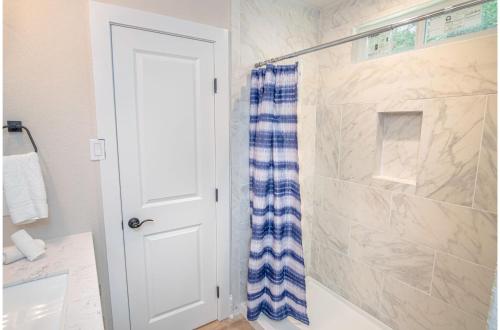 圣安东尼奥Brand New Remodeled 3BR2BA House Near Downtown的浴室设有蓝色和白色的淋浴帘